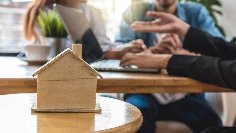 a small house on a table with people in the background