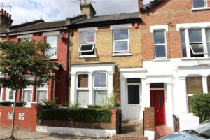Terraced houses with a parked car in front of the row.