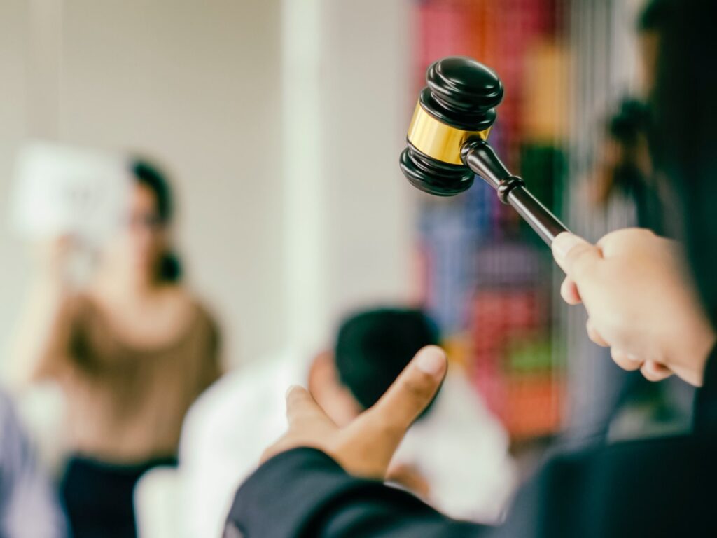 A judge with a gavel addressing a group of attentive people.