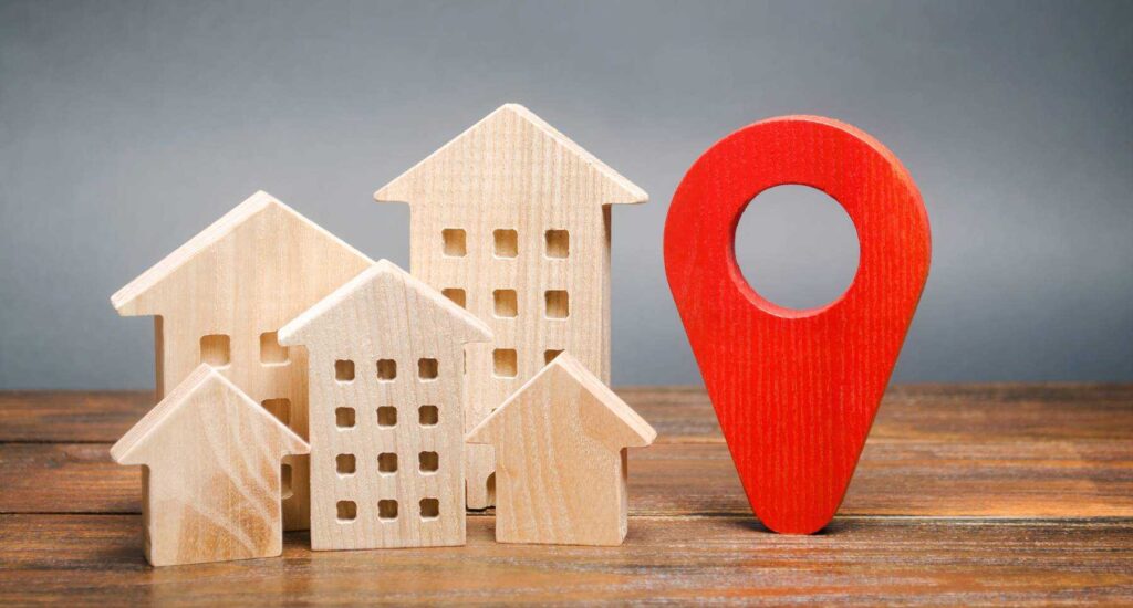 a wooden house with a red marker marker on top of it