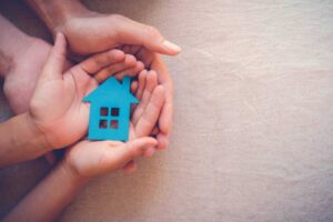 a person holding a small house in their hands