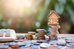 a house and coins on a table