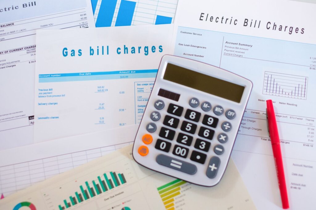 Calculator and bills arranged neatly on a desk surface.
