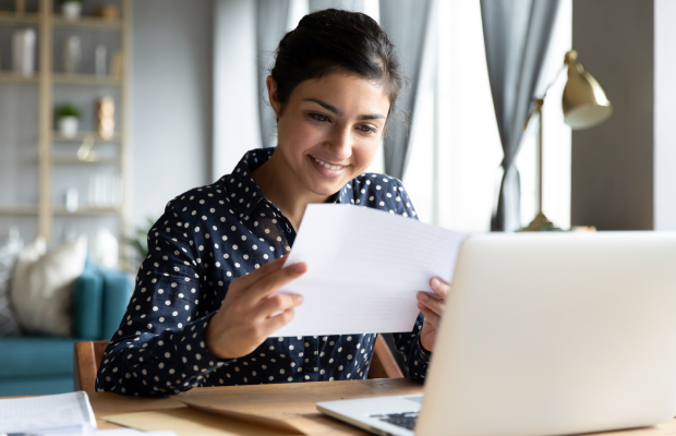 a woman sitting at a desk with a laptop and papers