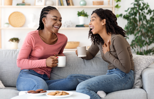 two women sitting on a couch talking