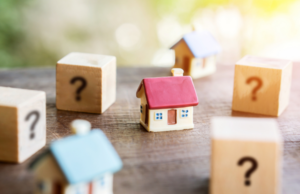 a small house surrounded by wooden blocks with question marks on them