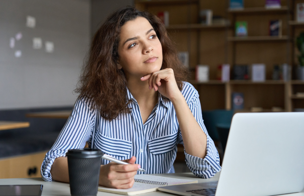 a woman sitting at a table with a laptop