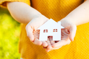 a child holding a paper house in her hands