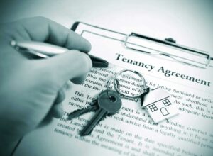 a person holding a pen and signing a document