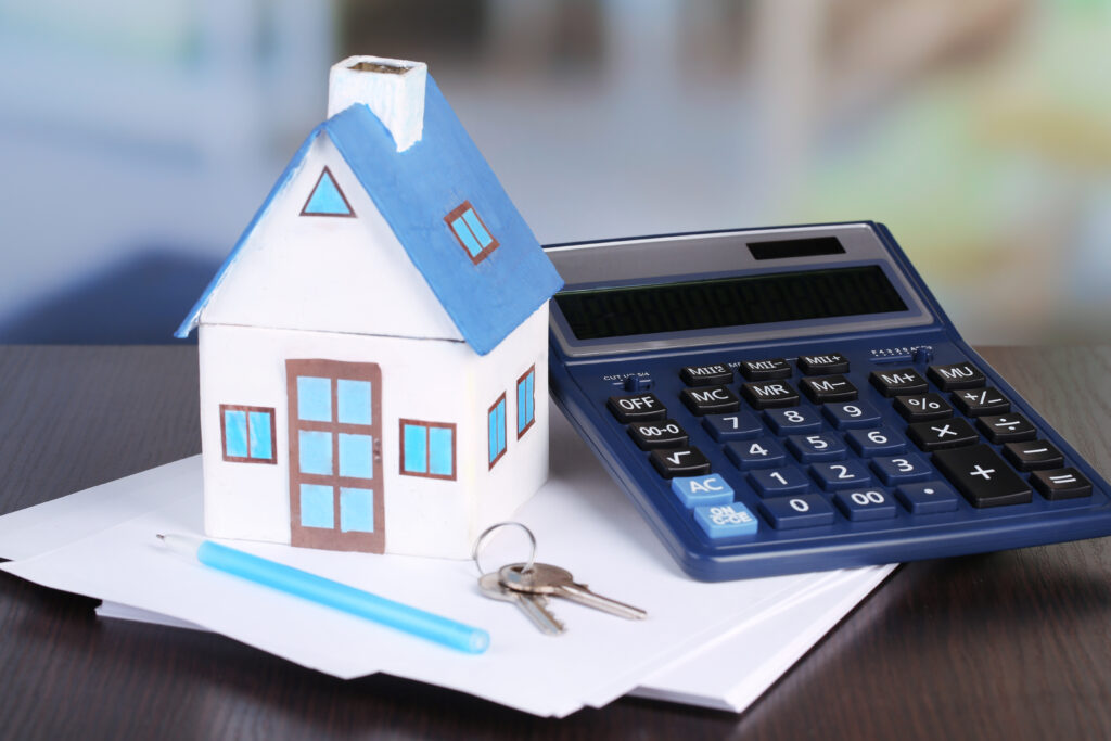 a house and calculator on a desk