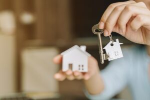 a woman holding a house key in her hand