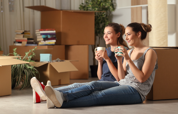 two women sitting on the floor with boxes and boxes