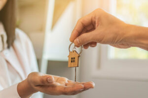 a man handing a house key to woman