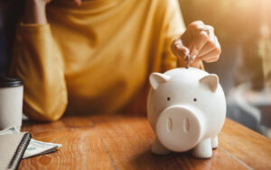 a woman putting a coin into a piggy