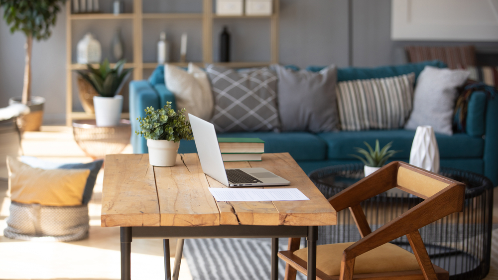 a living room with a couch, a table, and a laptop
