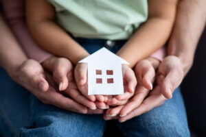 a man holding a small house in his hands
