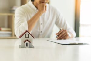 a man sitting at a table with a model house
