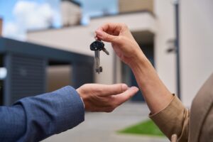 a woman handing a house key to a man