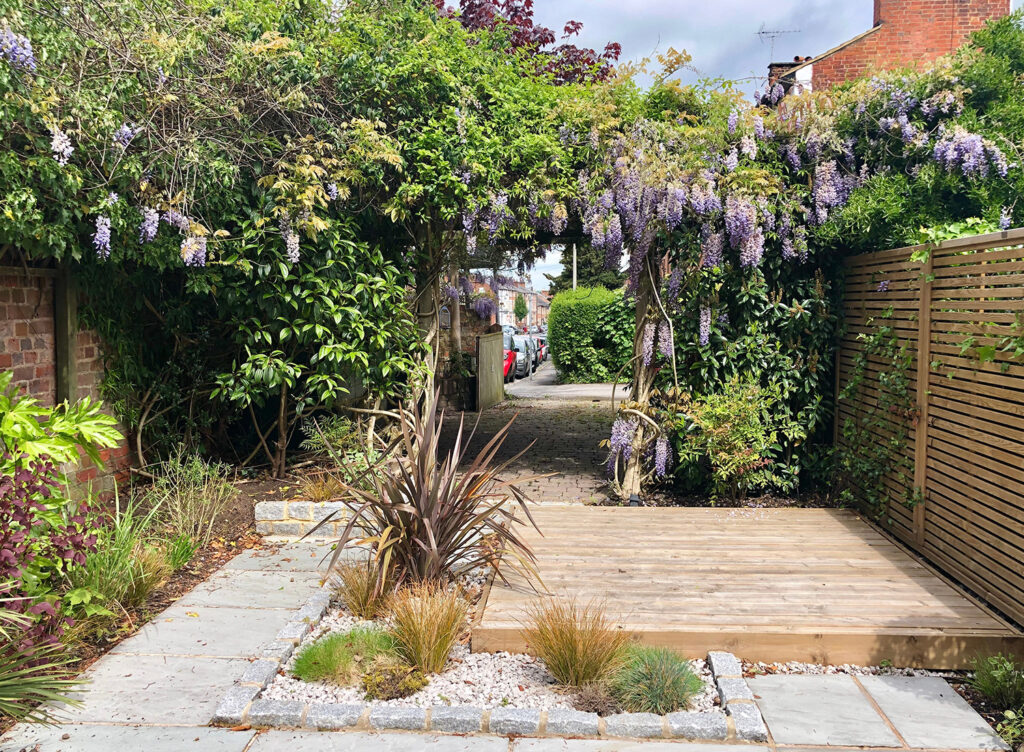 a garden with a stone path and a wooden fence