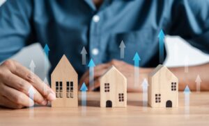 Man with a house model, arrows, and a graph showing housing prices