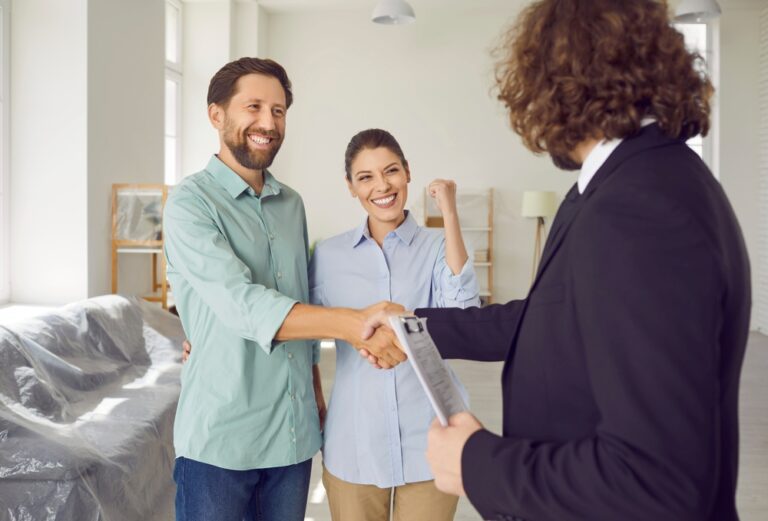 A man and woman shaking hands in a professional setting.