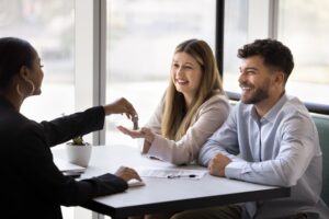 A couple meets with a real estate agent to discuss property options.
