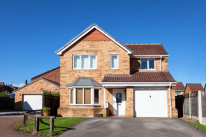 Large brick home with a garage and driveway, featured in a blog post.