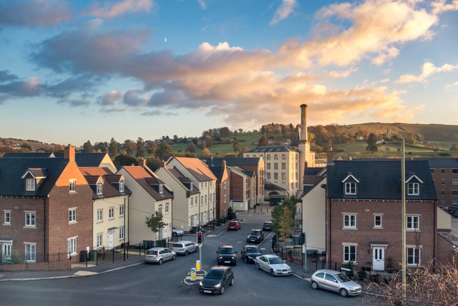 Row of modern UK houses with cars parked on the street