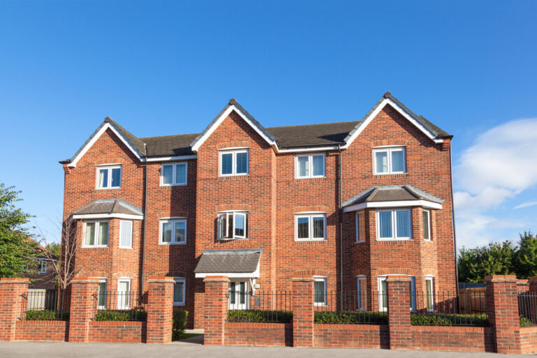 Large brick building with multiple windows and a sturdy facade.