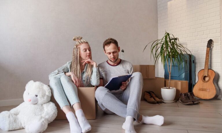 Homeowners sitting among packed boxes reviewing paperwork while preparing to sell their Tonbridge home in January