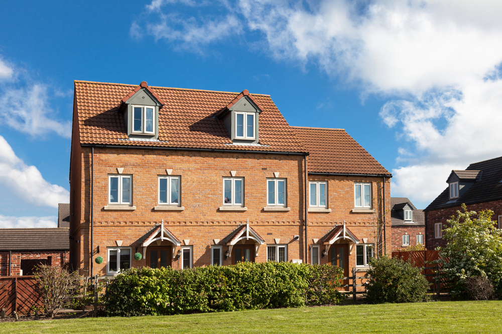 A large brick house with a sloped roof and multiple windows.