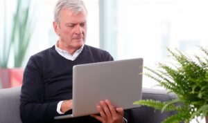 Landlord reviewing tenant applications on laptop at home