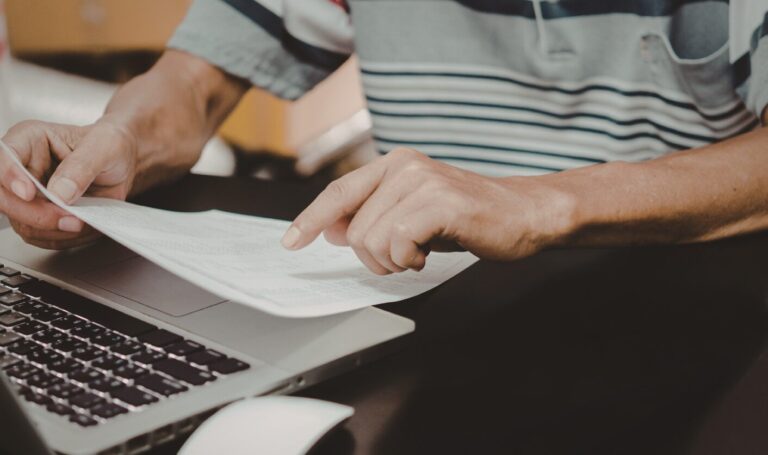Landlord reviewing tenant applications at desk in modern London flat