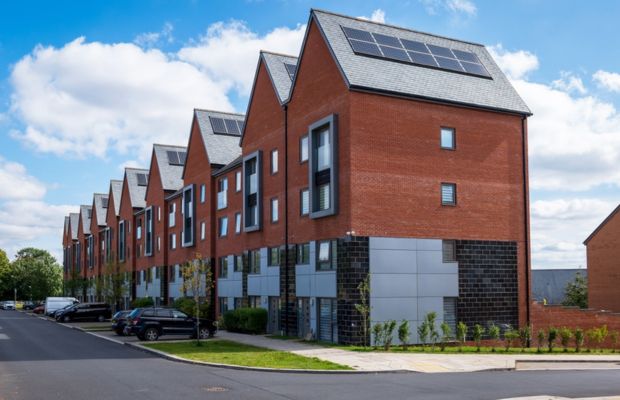 Row of modern brick houses with solar panels