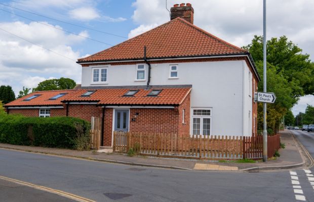 Two-story house with a red tiled roof.