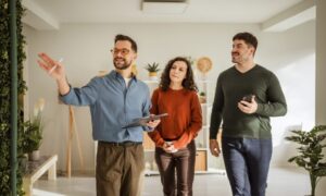 Estate agent showing a couple around a modern home during a property viewing
