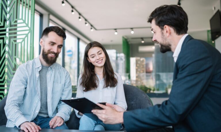 Letting agent discussing documents with tenants, representing Bounds Green landlord licensing, Haringey compliance and rental property management.