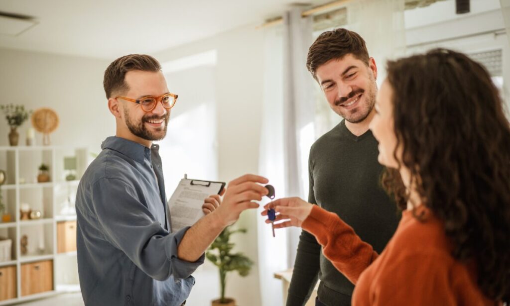 Letting agent handing keys to tenants inside a rental property, representing Tonbridge rental demand, fast-letting areas and landlord property management.
