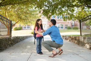 Parent with child outside a school, representing school catchment demand and family property searches in north Tonbridge.