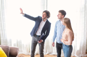 Estate agent showing a couple around a bright property, representing buyers viewing a home in Bounds Green.