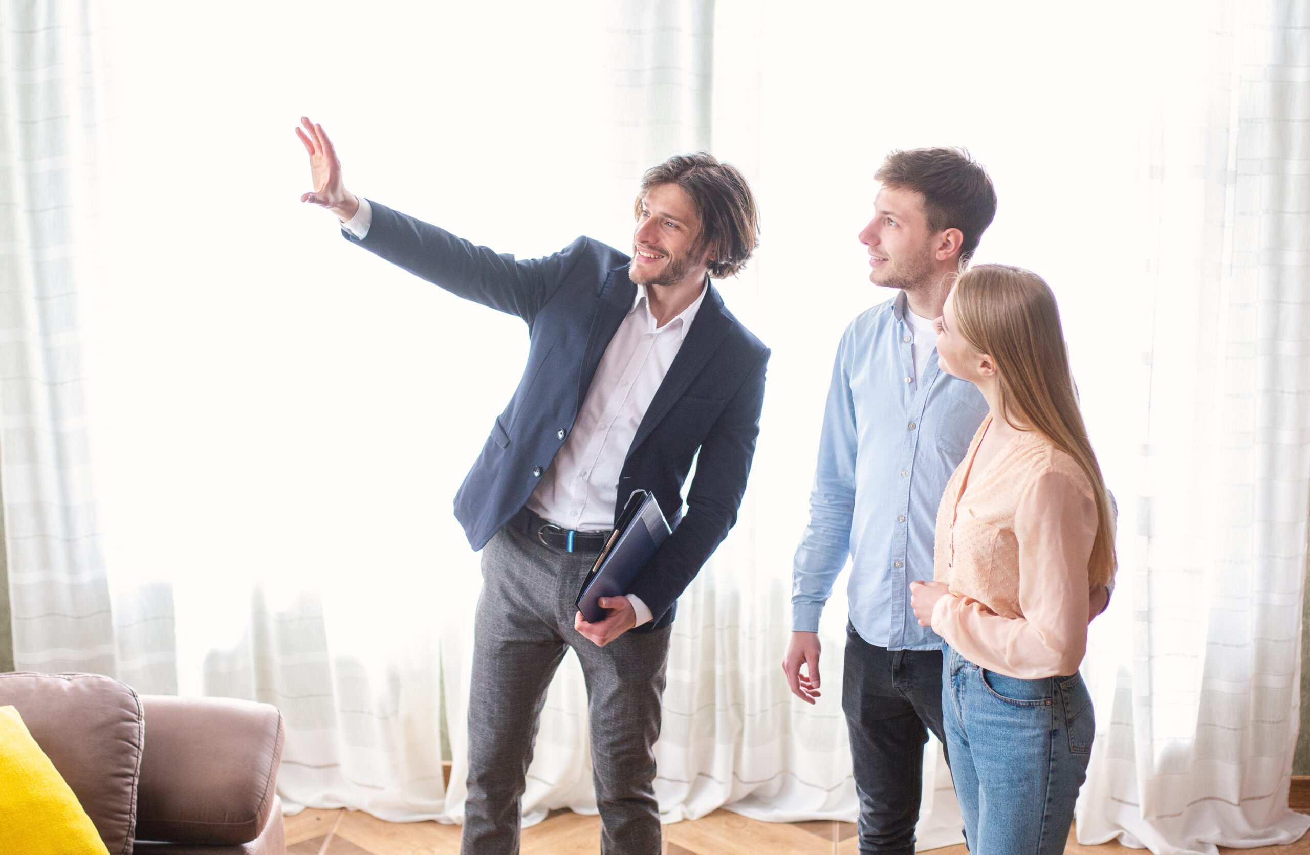 Estate agent showing a couple around a bright property, representing buyers viewing a home in Bounds Green.