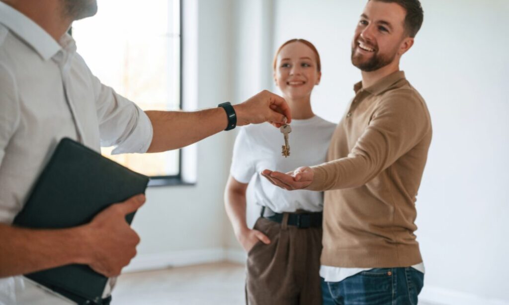 Letting agent handing property keys to tenants, representing professional property management and successful tenancies in Bounds Green.