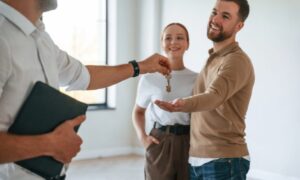 Letting agent handing property keys to tenants, representing professional property management and successful tenancies in Bounds Green.