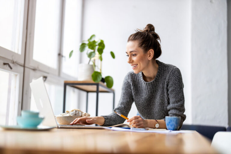 Woman researching property online from home while comparing places to live in the TN11 area.