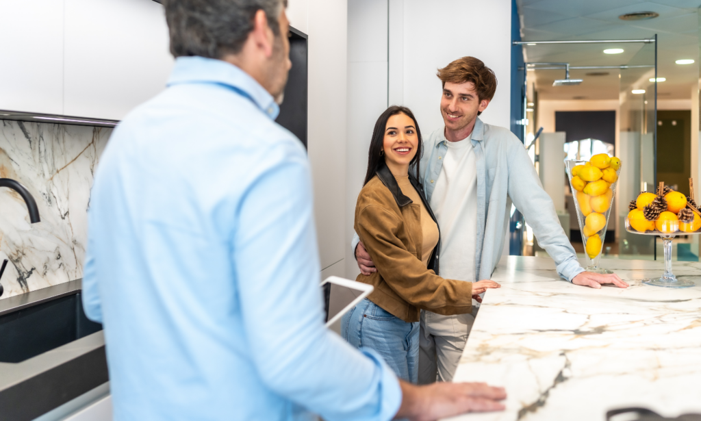 Couple speaking with an estate agent while viewing a modern home in preparation for a property move.
