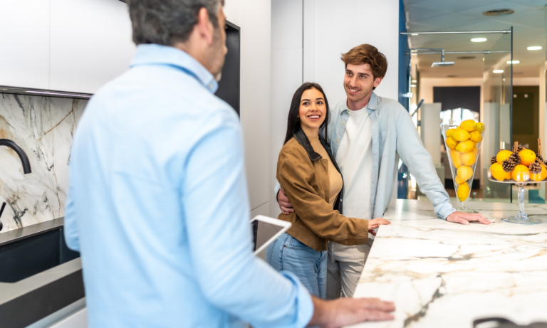 Couple speaking with an estate agent while viewing a modern home in preparation for a property move.