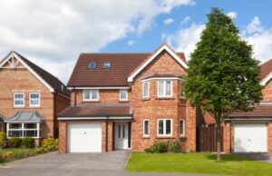 A large brick house featuring two attached garages on either side.