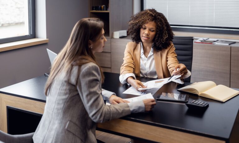 Two people reviewing leasehold documents and service charge accounts for a flat in Bounds Green