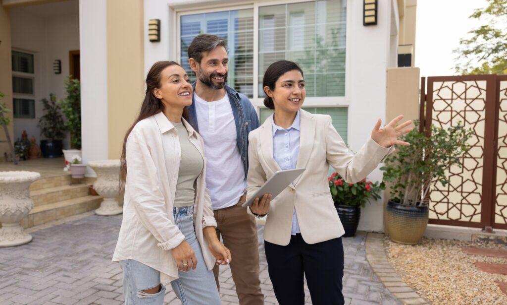 Buyers talking with an estate agent outside a house while comparing Tonbridge and Tunbridge Wells