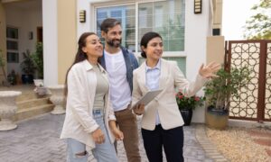 Buyers talking with an estate agent outside a house while comparing Tonbridge and Tunbridge Wells